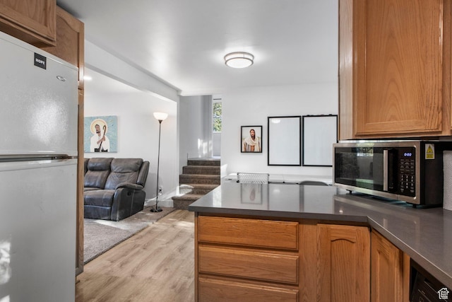 480 S 1160 W, Orem, UT 84058 - kitchen with freestanding refrigerator, stainless steel microwave, open floor plan, light wood-style floors, and a peninsula