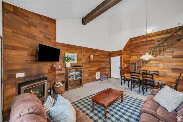 407 S Vasels Rd Unit 27, Brian Head, UT 84719 - living room with wood walls, stairway, high vaulted ceiling, a glass covered fireplace, and beamed ceiling