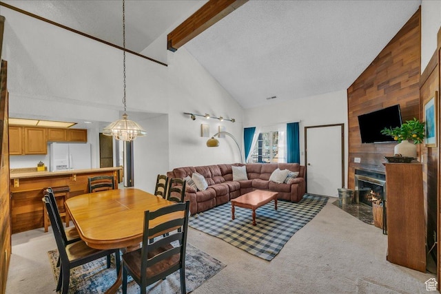 407 S Vasels Rd Unit 27, Brian Head, UT 84719 - living room with a chandelier, high vaulted ceiling, beamed ceiling, light carpet, and a large fireplace