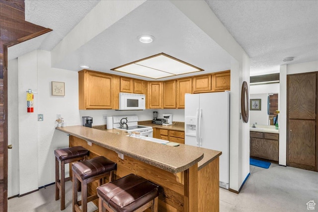 407 S Vasels Rd Unit 27, Brian Head, UT 84719 - kitchen featuring white appliances, a peninsula, a textured ceiling, a kitchen breakfast bar, and a sink