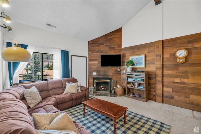 407 S Vasels Rd Unit 27, Brian Head, UT 84719 - carpeted living area with high vaulted ceiling, wooden walls, a large fireplace, and a textured ceiling