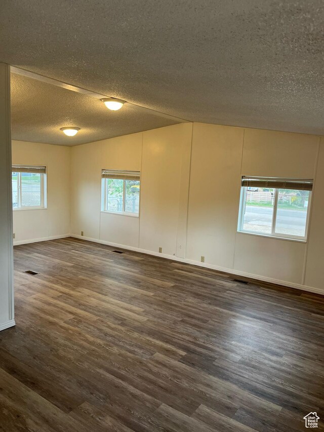 380 W Main, Myton, UT 84052 - unfurnished room featuring a textured ceiling, dark wood finished floors, and healthy amount of natural light
