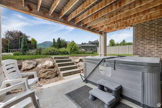 6035 Hidden Valley Rd, Mountain Green, UT 84050 - view of patio / terrace featuring a hot tub, a trampoline, and a mountain view