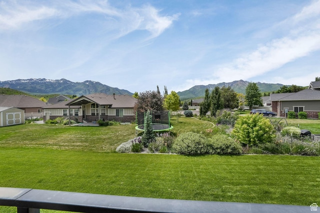 6035 Hidden Valley Rd, Mountain Green, UT 84050 - view of grassy yard with a trampoline, a mountain view, and a residential view