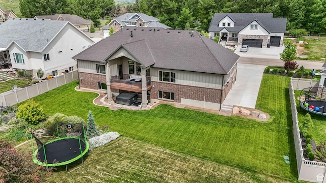 6035 Hidden Valley Rd, Mountain Green, UT 84050 - rear view of house featuring a trampoline, brick siding, a jacuzzi, and a patio