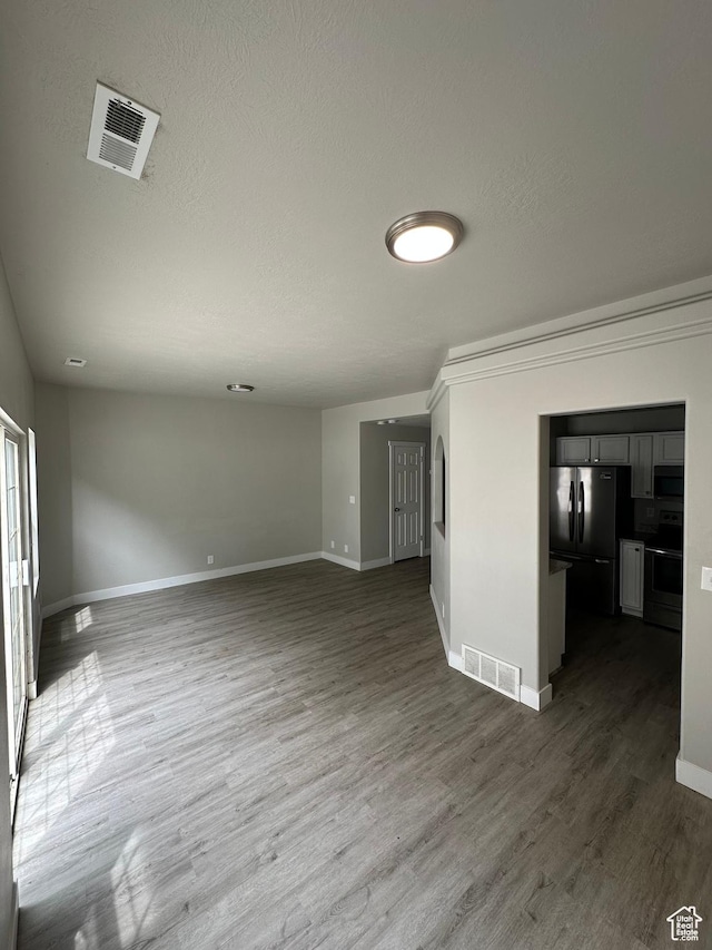 39 W 1930 N, Tooele, UT 84074 - unfurnished living room with baseboards, dark wood-style flooring, and a textured ceiling