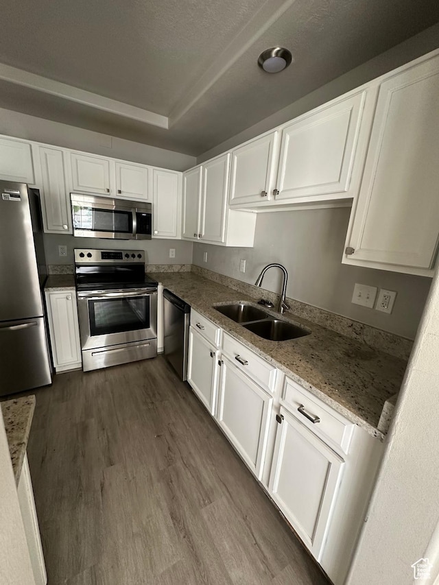 39 W 1930 N, Tooele, UT 84074 - kitchen featuring appliances with stainless steel finishes, a sink, white cabinetry, dark wood-type flooring, and light stone countertops