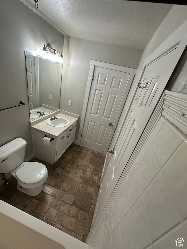 39 W 1930 N, Tooele, UT 84074 - bathroom with toilet, a textured ceiling, vanity, and stone finish floors