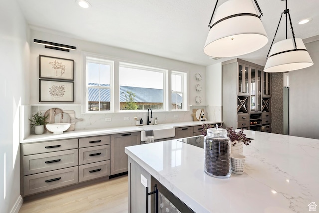 11214 S Easy Bee Rd, South Jordan, UT 84009 - kitchen with light stone countertops, a sink, light wood-style floors, decorative backsplash, and recessed lighting