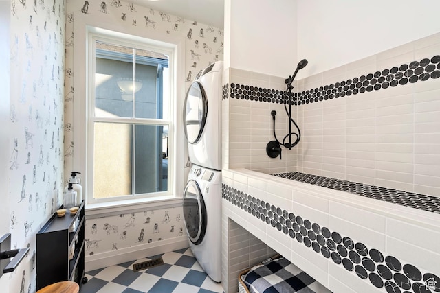 11214 S Easy Bee Rd, South Jordan, UT 84009 - bathroom with estacked washer and dryer, a tile shower, tile patterned floors, and wallpapered walls