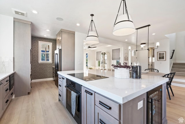 11214 S Easy Bee Rd, South Jordan, UT 84009 - kitchen with black appliances, wine cooler, light wood-style flooring, gray cabinets, and light stone counters