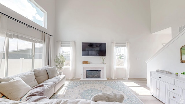 585 W 1420 S, Spanish Fork, UT 84660 - living room featuring a towering ceiling, a fireplace, light wood finished floors, and baseboards