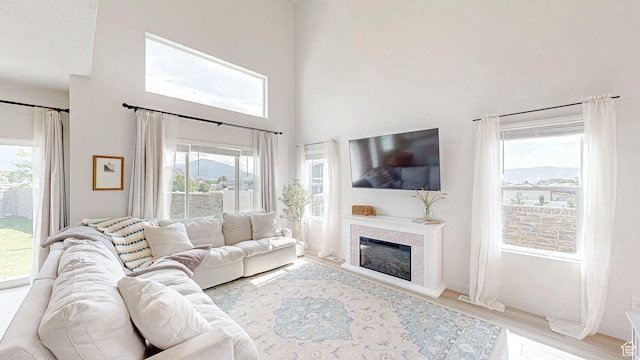 585 W 1420 S, Spanish Fork, UT 84660 - living area featuring plenty of natural light, wood finished floors, a glass covered fireplace, a high ceiling, and baseboards