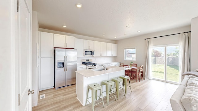 585 W 1420 S, Spanish Fork, UT 84660 - kitchen featuring appliances with stainless steel finishes, a sink, open floor plan, light wood finished floors, and a breakfast bar area