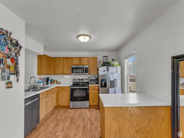 1177 W Dun Robin Ct, Salt Lake City, UT 84123 - kitchen with stainless steel appliances, a sink, light wood-style flooring, light countertops, and a peninsula