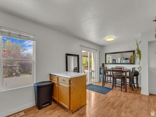 1177 W Dun Robin Ct, Salt Lake City, UT 84123 - kitchen with a peninsula, light wood-style floors, brown cabinets, light countertops, and baseboards