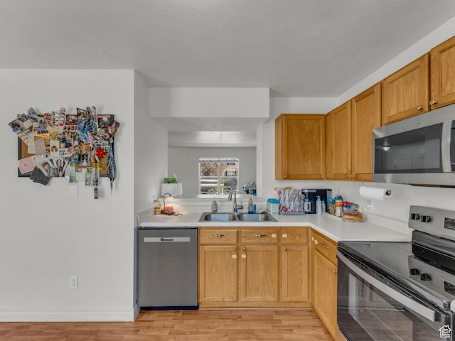 1177 W Dun Robin Ct, Salt Lake City, UT 84123 - kitchen with appliances with stainless steel finishes, a sink, light countertops, and light wood-style flooring