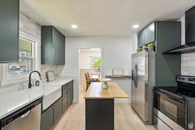 669 W 6th Ave, Midvale, UT 84047 - kitchen featuring stainless steel appliances, wall chimney range hood, backsplash, light wood-style flooring, and recessed lighting