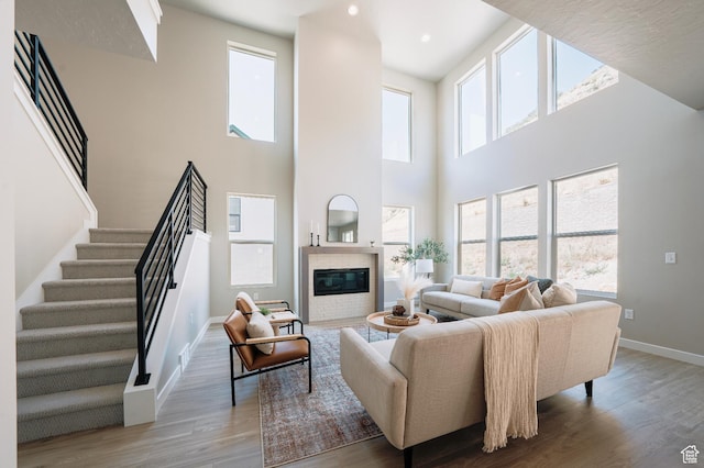 1651 W Canyon Rim Rd Unit 633, Lehi, UT 84043 - living room with baseboards, wood finished floors, stairs, healthy amount of natural light, and a towering ceiling
