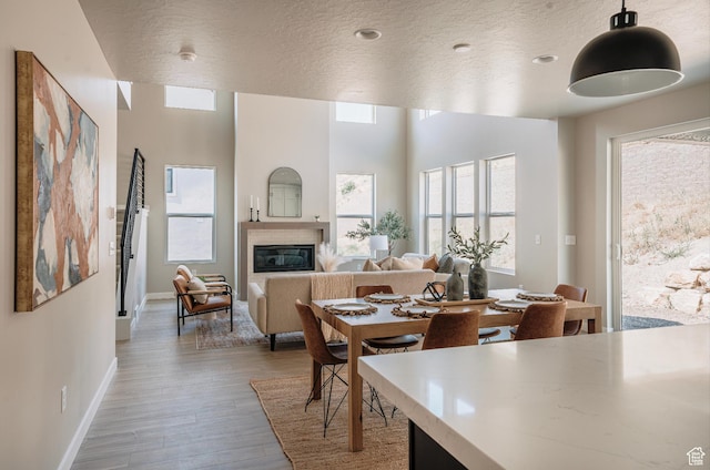 1651 W Canyon Rim Rd Unit 633, Lehi, UT 84043 - dining area featuring a textured ceiling, baseboards, wood finished floors, and a glass covered fireplace