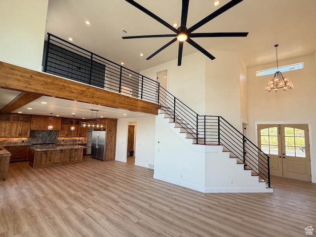 1141 E 4100 N, North Ogden, UT 84414 - unfurnished living room featuring a towering ceiling, stairs, light wood-type flooring, baseboards, and a ceiling fan