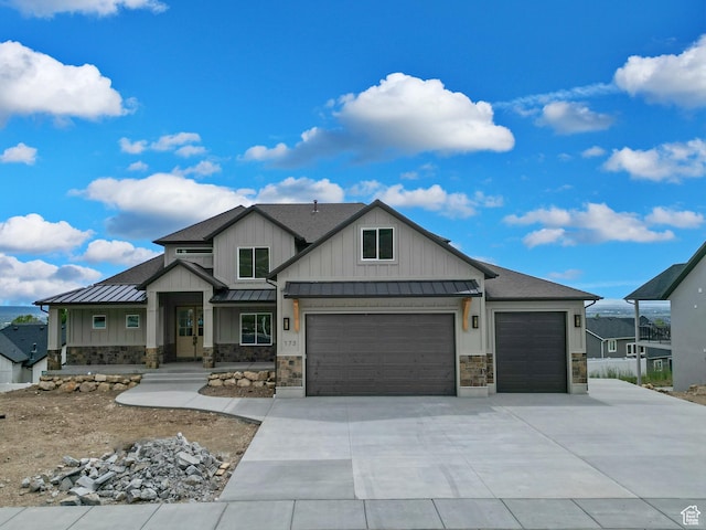 1141 E 4100 N, North Ogden, UT 84414 - view of front facade with a standing seam roof, stone siding, an attached garage, metal roof, and driveway