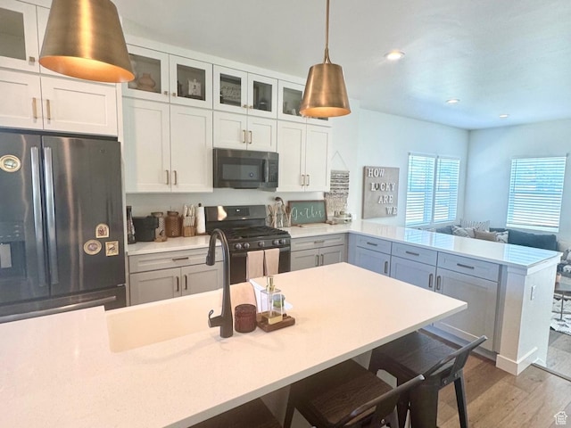 953 N 850 E Unit 229, Layton, UT 84041 - kitchen featuring appliances with stainless steel finishes, a peninsula, light countertops, glass insert cabinets, and recessed lighting