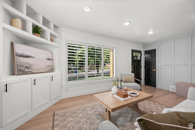 2524 E Redondo Ave, Salt Lake City, UT 84108 - living area with recessed lighting, light wood-type flooring, a textured ceiling, and a decorative wall