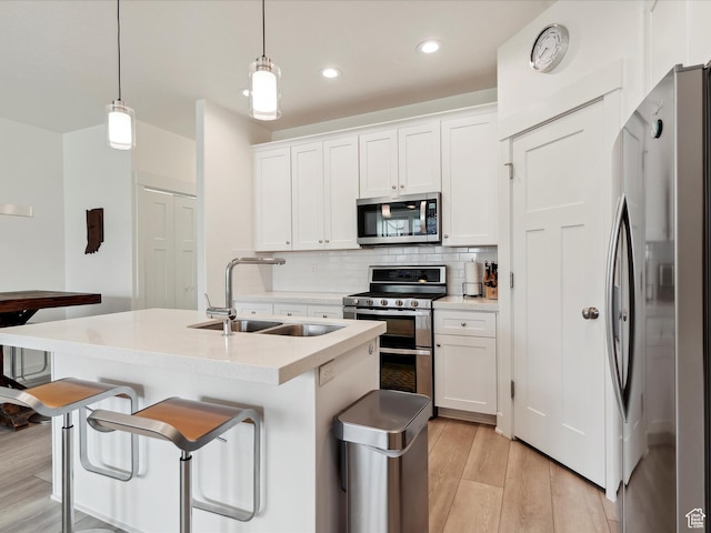 335 E Park Blvd S, Ogden, UT 84401 - kitchen featuring stainless steel appliances, a sink, backsplash, light wood-style floors, and white cabinets