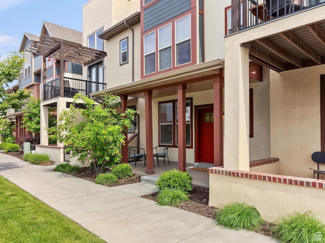 335 E Park Blvd S, Ogden, UT 84401 - doorway to property with a porch, stucco siding, a balcony, and a pergola