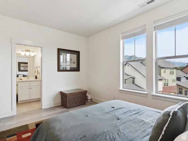 335 E Park Blvd S, Ogden, UT 84401 - bedroom with multiple windows, light wood-style floors, baseboards, and connected bathroom