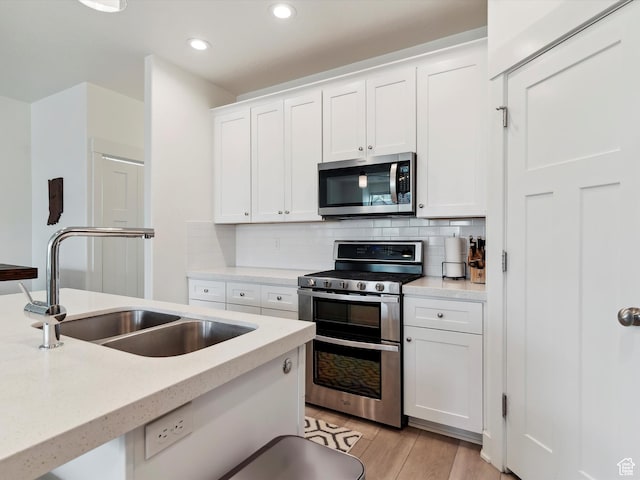 335 E Park Blvd S, Ogden, UT 84401 - kitchen with appliances with stainless steel finishes, a sink, white cabinetry, tasteful backsplash, and recessed lighting