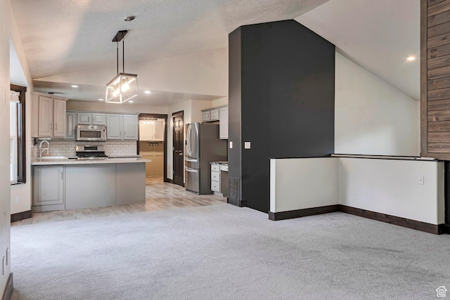 2101 W 325 S, Mapleton, UT 84664 - kitchen with appliances with stainless steel finishes, vaulted ceiling, light colored carpet, a peninsula, and backsplash