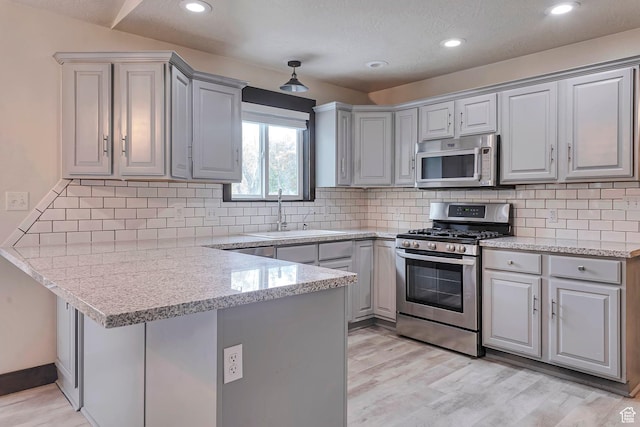 2101 W 325 S, Mapleton, UT 84664 - kitchen featuring appliances with stainless steel finishes, a peninsula, gray cabinetry, light wood-style flooring, and recessed lighting