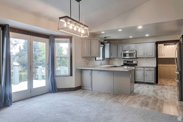 2101 W 325 S, Mapleton, UT 84664 - kitchen with stainless steel appliances, gray cabinetry, a peninsula, lofted ceiling, and decorative backsplash