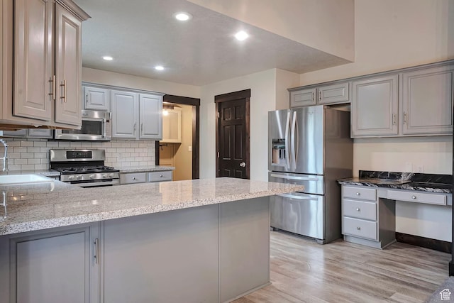 2101 W 325 S, Mapleton, UT 84664 - kitchen featuring stainless steel appliances, gray cabinetry, a peninsula, light wood-style floors, and decorative backsplash