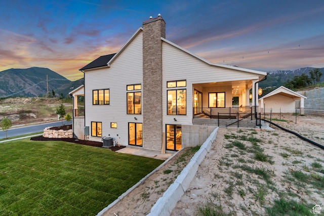 1366 S 370 E, Salem, UT 84653 - back of house at dusk with a yard, a mountain view, central AC, and a chimney