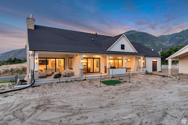 1366 S 370 E, Salem, UT 84653 - back of house at dusk with a chimney, board and batten siding, a mountain view, and covered porch