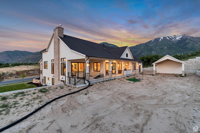 1366 S 370 E, Salem, UT 84653 - back of house at dusk featuring a chimney, a mountain view, and covered porch