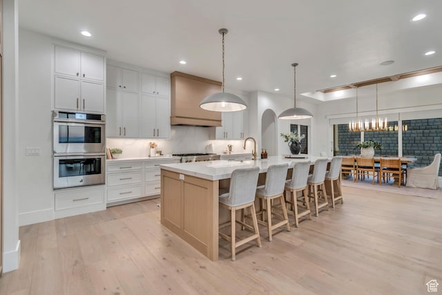 1366 S 370 E, Salem, UT 84653 - kitchen featuring stainless steel appliances, light wood-style flooring, a kitchen island with sink, a chandelier, and a kitchen bar