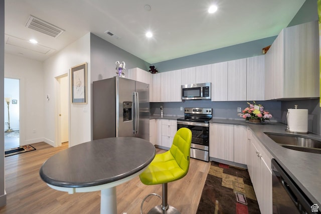 3610 S 805 E Unit 233, Millcreek, UT 84106 - kitchen featuring appliances with stainless steel finishes, wood finished floors, modern cabinets, recessed lighting, and dark countertops