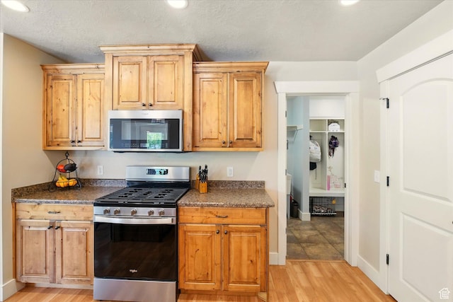 674 S 150 W, Hyde Park, UT 84318 - kitchen with stainless steel appliances, light wood-style flooring, dark countertops, and baseboards
