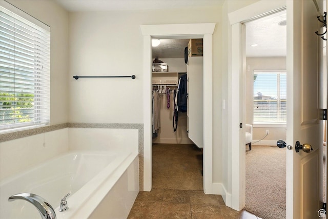 674 S 150 W, Hyde Park, UT 84318 - full bath featuring a garden tub, plenty of natural light, tile patterned floors, and a walk in closet