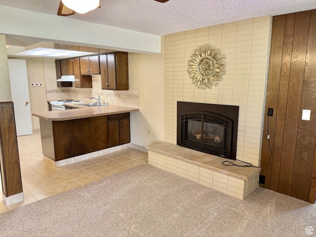 5253 S 2150 W, Roy, UT 84067 - kitchen with white electric stove, a peninsula, tasteful backsplash, a fireplace, and light countertops
