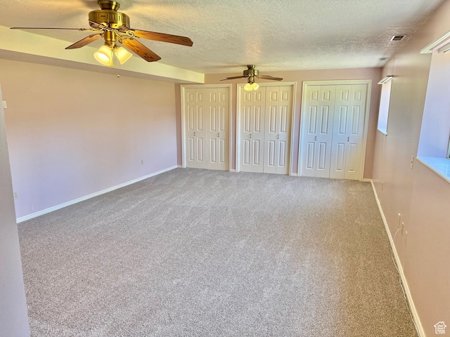 5253 S 2150 W, Roy, UT 84067 - unfurnished bedroom with a textured ceiling, multiple closets, carpet, baseboards, and ceiling fan