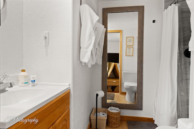 332 W Pinehurst Dr, Brian Head, UT 84719 - full bath with toilet, vanity, curtained shower, a textured wall, and baseboards