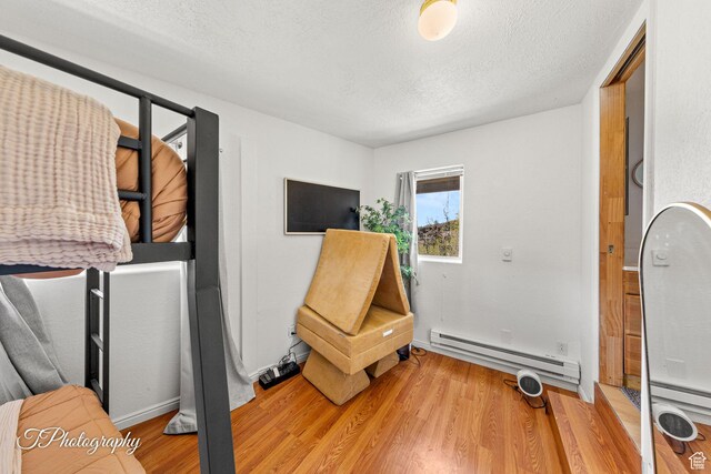 332 W Pinehurst Dr, Brian Head, UT 84719 - living area with a baseboard radiator, light wood-style floors, a textured ceiling, and baseboards