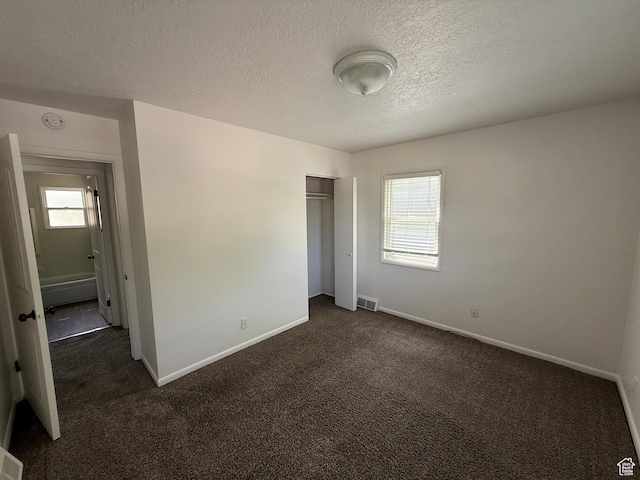 2168 S Harrison Blvd, Ogden, UT 84401 - unfurnished bedroom featuring multiple windows, dark carpet, and a textured ceiling