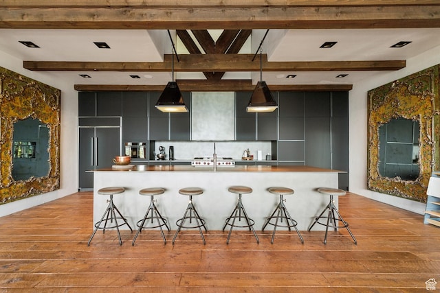 7701 N W Hills Trl, Park City, UT 84098 - kitchen featuring light wood-style floors, a kitchen breakfast bar, dark cabinets, modern cabinets, and beam ceiling