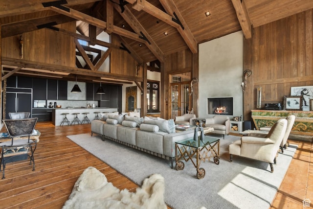 7701 N W Hills Trl, Park City, UT 84098 - living area with high vaulted ceiling, wood ceiling with exposed beams, wood finished floors, and wooden walls